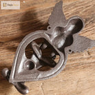 Cast iron angel door knocker close-up with heart knocker ring and winged figure, dark finish