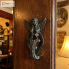 Cast iron angel door knocker ornament with wings and heart-shaped handle, dark bronze