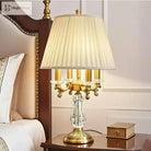 Gold art deco desk lamp with pleated shade, clear crystal body, and ornate arms