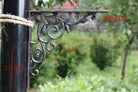 Cast iron right-angle shelf bracket with ornate scrolls, dark bronze finish
