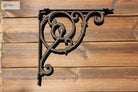 Black cast iron triangle shelf bracket with round ring scroll motif