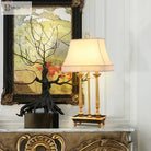 Brass LED desk lamp with beige shade and ornate gold frame on a console