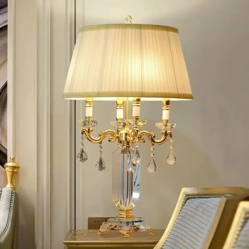 Gold LED table lamp with pleated fabric shade and clear crystal dangling ornaments