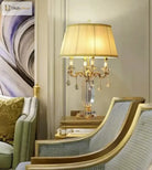 Gold LED table lamp with pleated shade and clear crystal charms on ornate candelabra