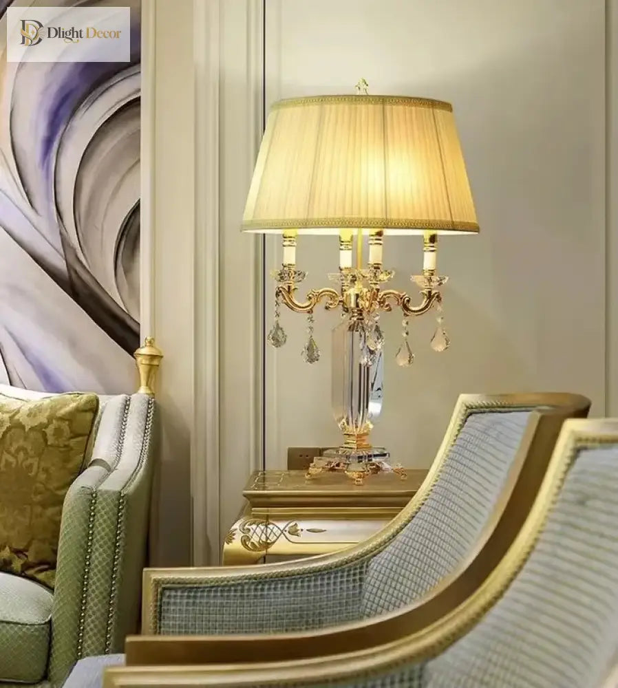 Gold LED table lamp with pleated shade and clear crystal charms on ornate candelabra