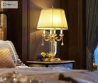 Gold LED table lamp with pleated fabric shade and crystal chandelier-style arms