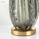 Green crystal glass lamp base with brass pedestal, detailed textured surface