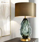 LED desk lamp with green wavy crystal glass base and large beige fabric shade