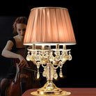 Gold crystal table lamp with pleated drum shade and dangling drops
