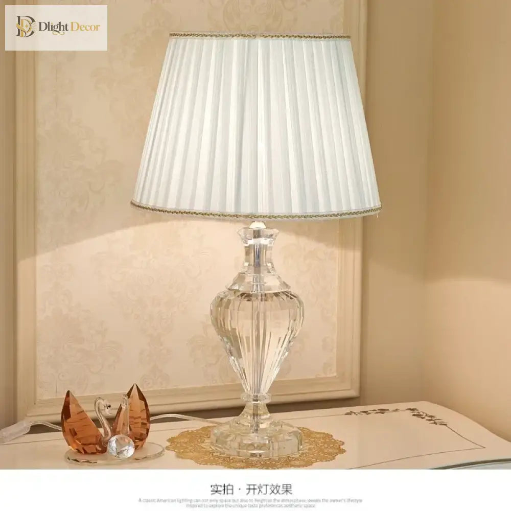 Full view crystal table lamp with pleated white shade and clear faceted base