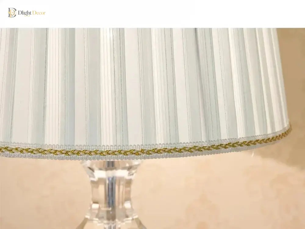 Pleated white lampshade with gold-trim edge and clear crystal lamp base