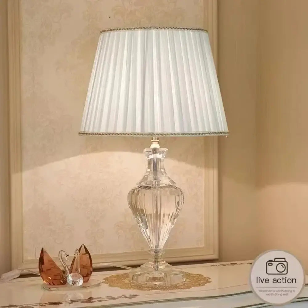 Side view crystal table lamp with pleated white shade and clear faceted base
