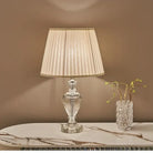 Crystal table lamp with pleated white fabric shade and clear faceted base