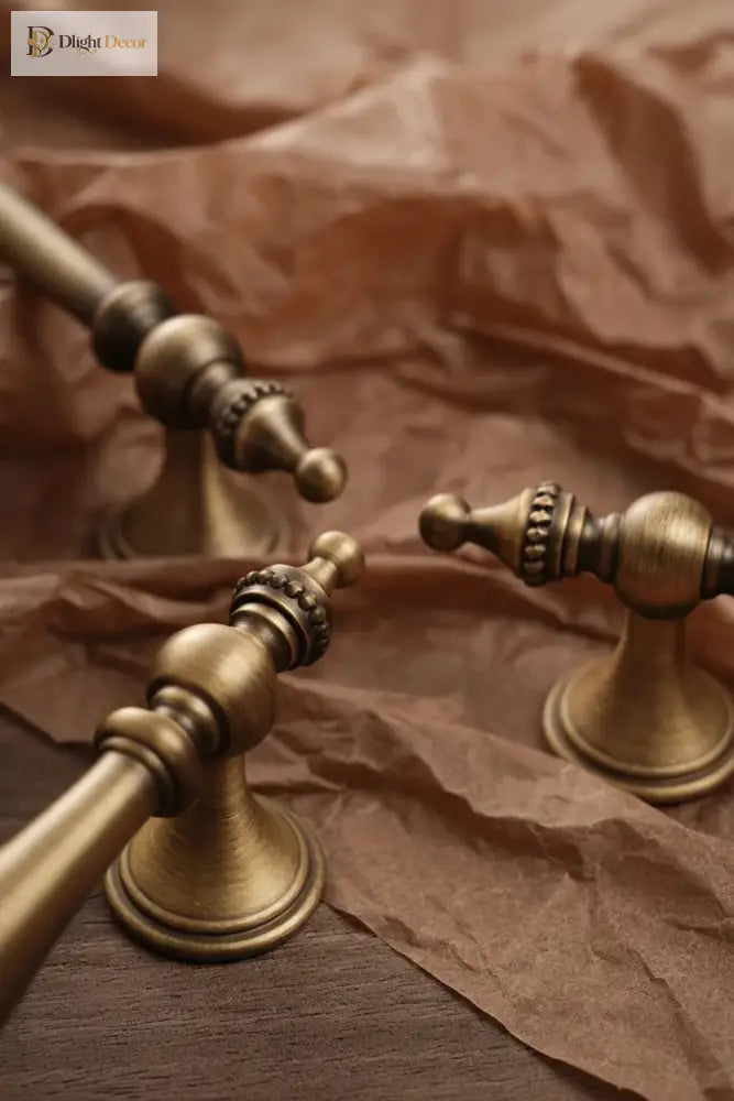 Antique brass cabinet handles with ornate round bases and ribbed mid sections