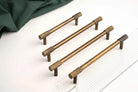 Antique brass cabinet pulls with cross-knurled grip, long bar style, pair shown