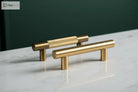 Antique brass cabinet pulls with cross-knurled textured barrels and short end posts