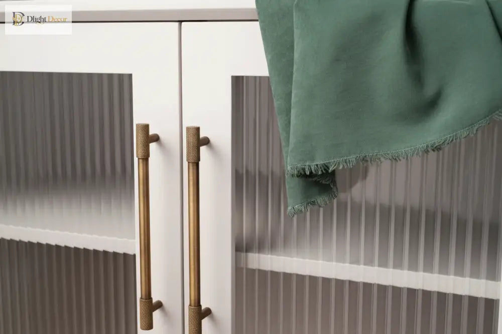 Antique brass cabinet pulls on door panels, cross-knurled textured barrels