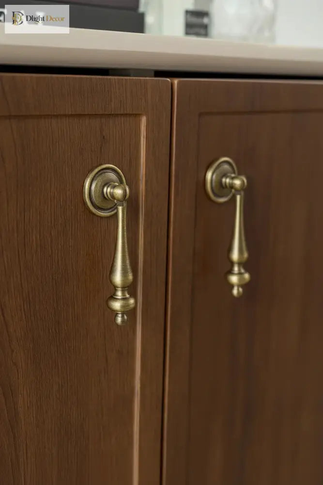 Antique brass cabinet handles with tapered finials and ribbed central detail