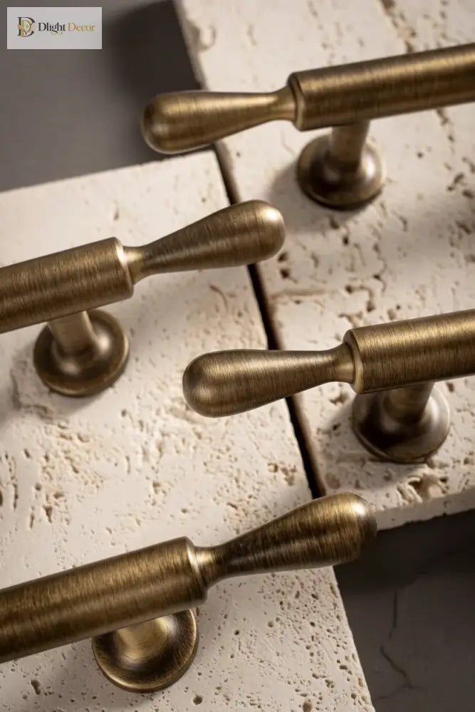 Antique brass bar cabinet handles with rounded bases mounted on a cabinet panel