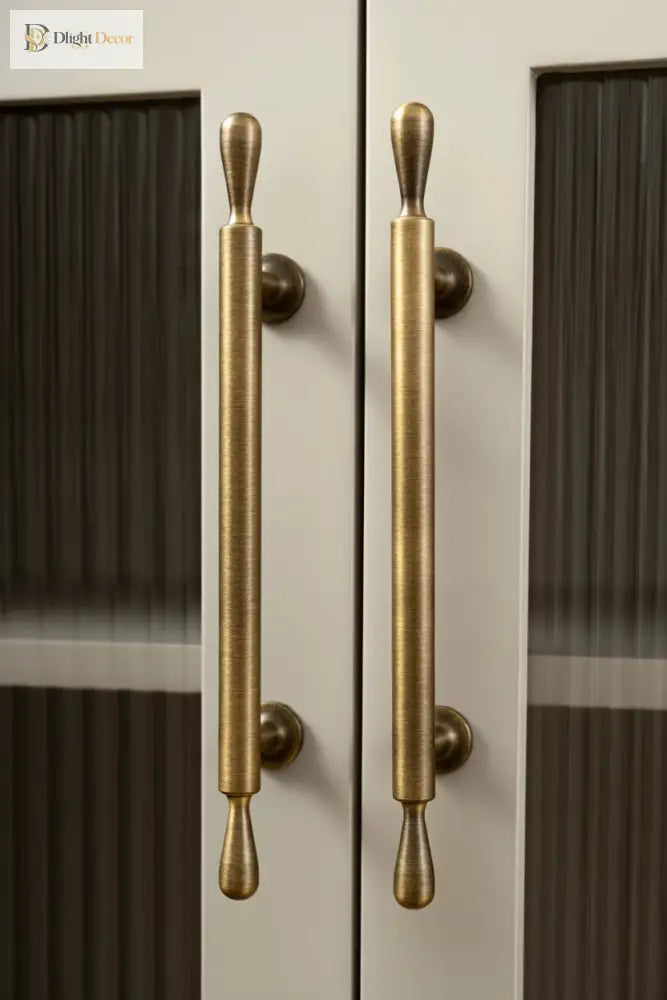 Brass door handles on a glass door with 'Santaya' branding.