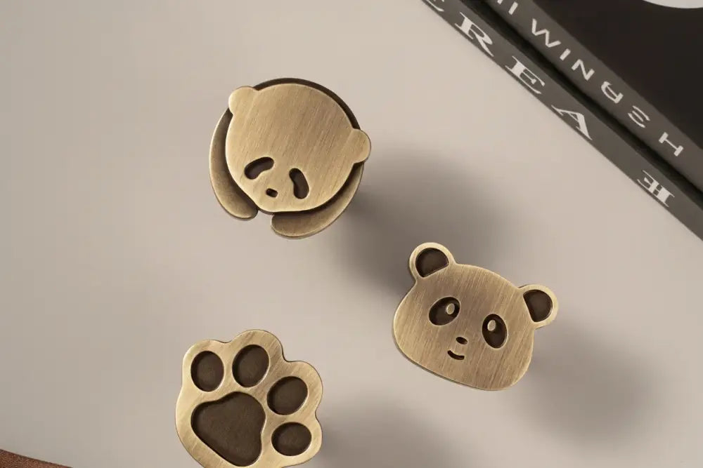 Brushed brass panda cabinet knobs: panda face and paw print shapes, single-hole style