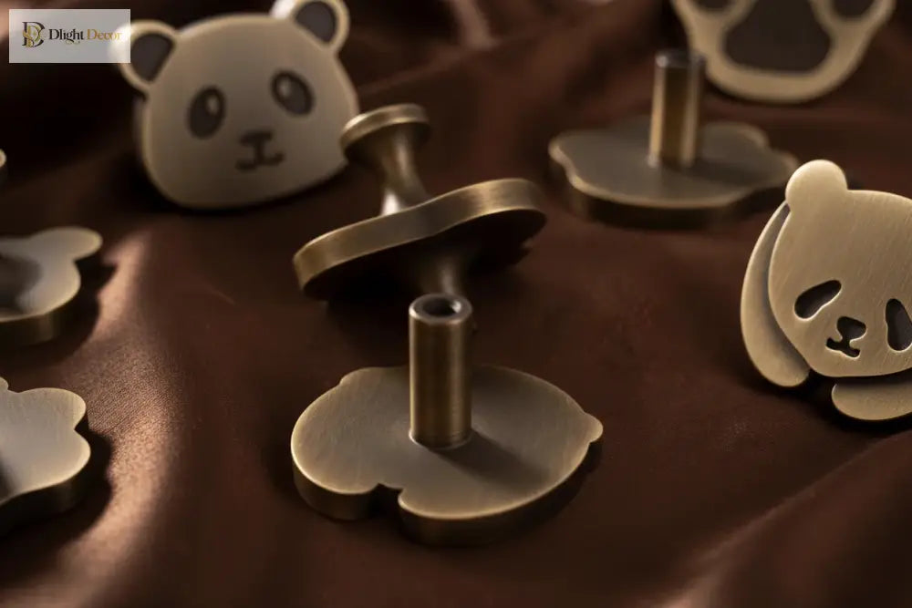 Brushed brass panda cabinet knobs with metal mounting posts and decorative bear-face shapes