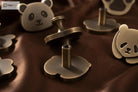 Brushed brass panda cabinet knobs with metal mounting posts and decorative bear-face shapes