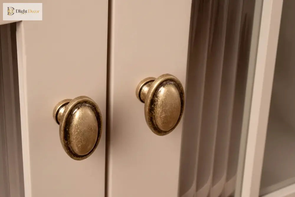 Antique brass cabinet knobs with oval tops on light cabinet doors