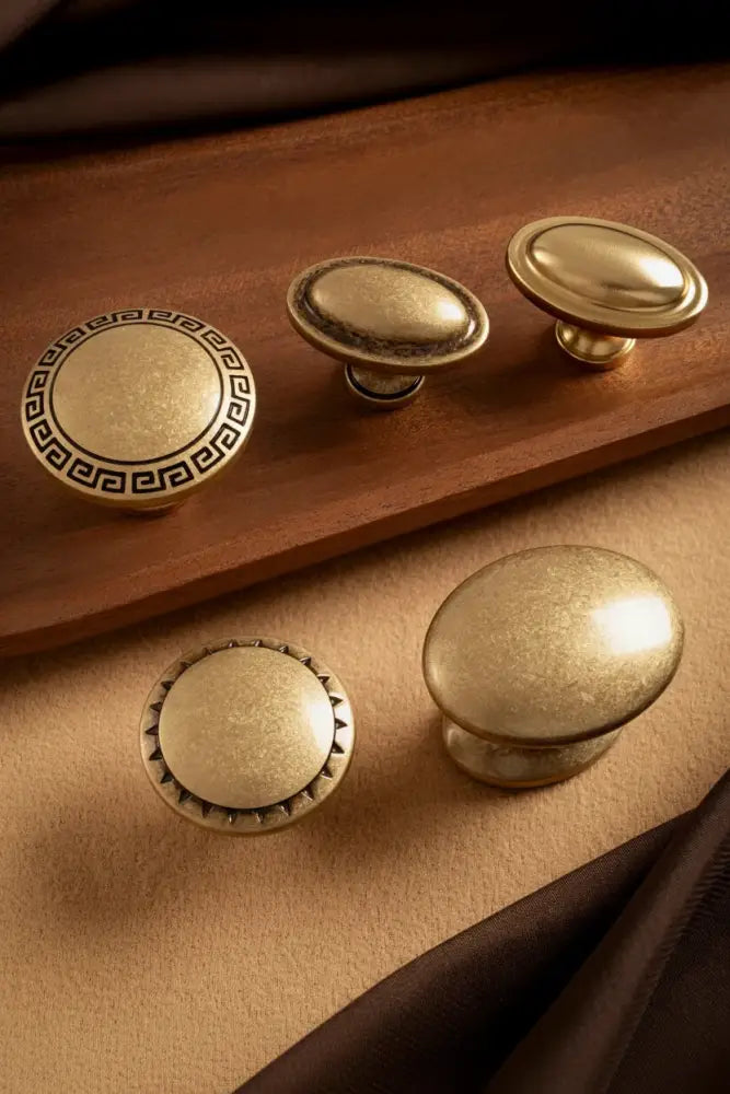 Antique brass cabinet knobs set with round tops and ornate Greek key rosette bases