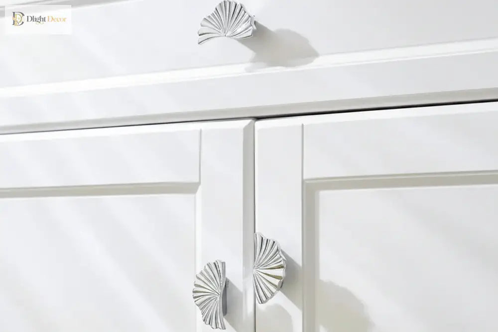 Ruffled cabinet handle pair in bright silver finish on white cabinet drawer.