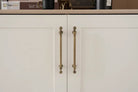 Pair of brushed brass cabinet handles with ornate vertical bar grips