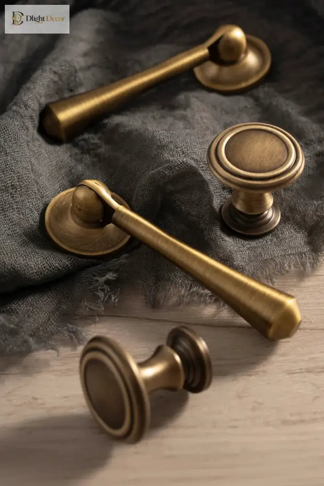 Antique brass cabinet pulls and round knob on dark fabric