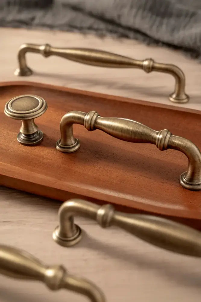 Antique brass T-bar cabinet pull with curved arms and rounded end caps