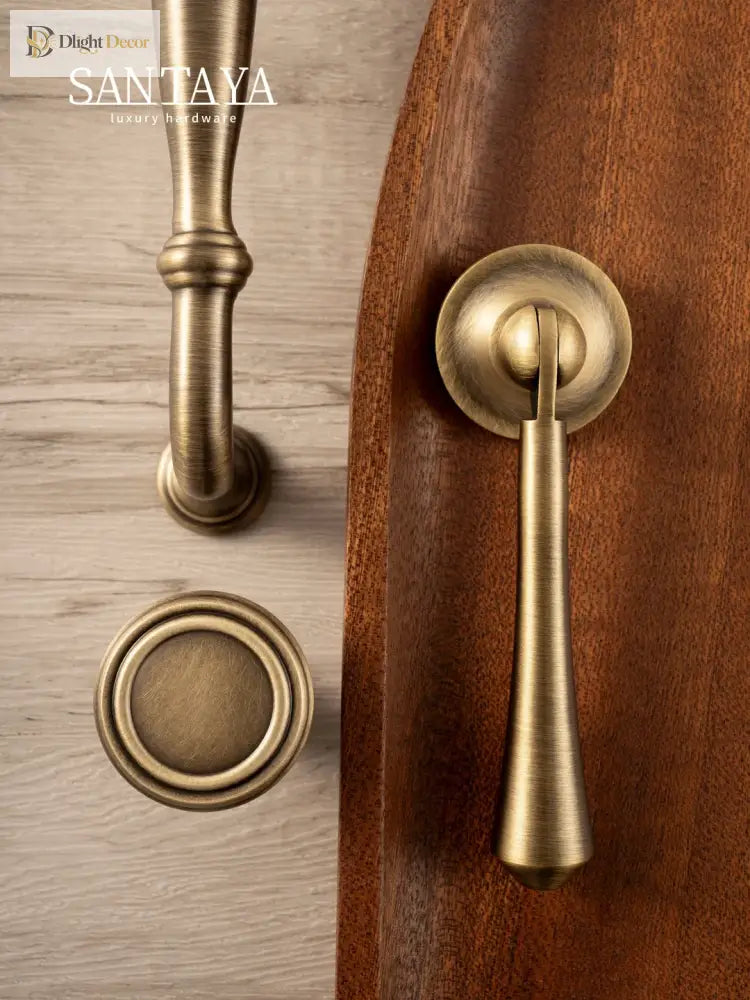 Antique brass cabinet pull and round knob on dark wood panel