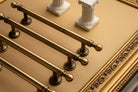 Set of brushed brass T-bar cabinet pulls with ball finial ends and curved base plates