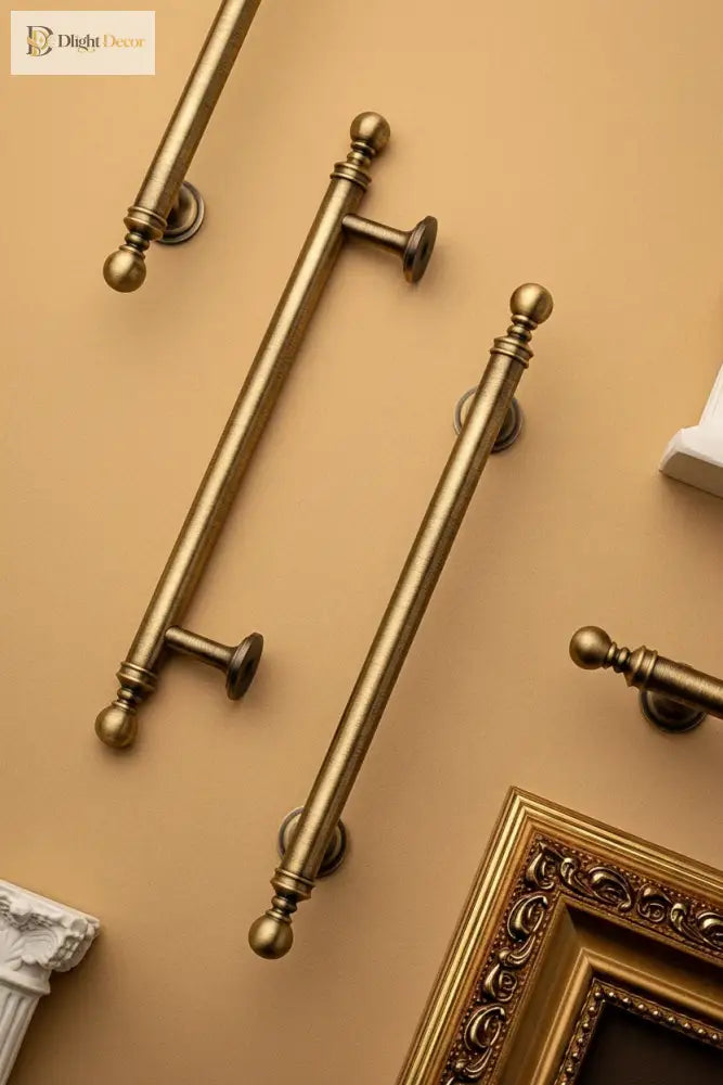 Brushed brass T-bar cabinet pull showing round finial ends and cylindrical support posts
