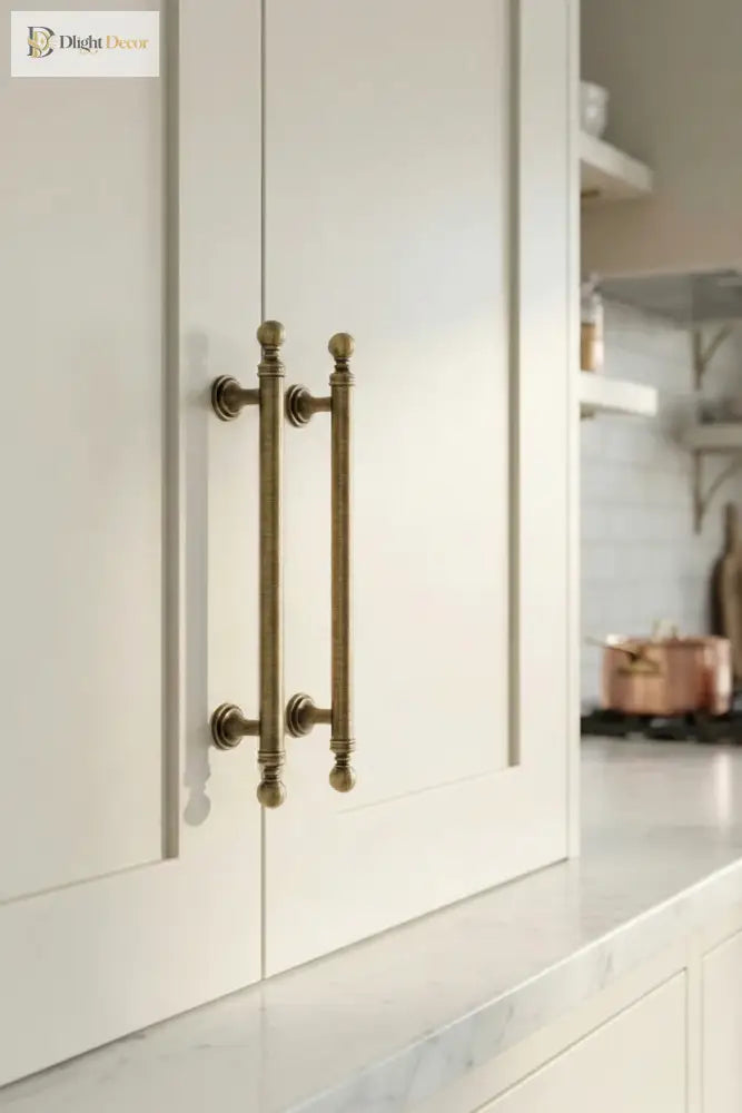 Brushed brass double T-bar cabinet pull on white cabinet door, wall-mounted handles