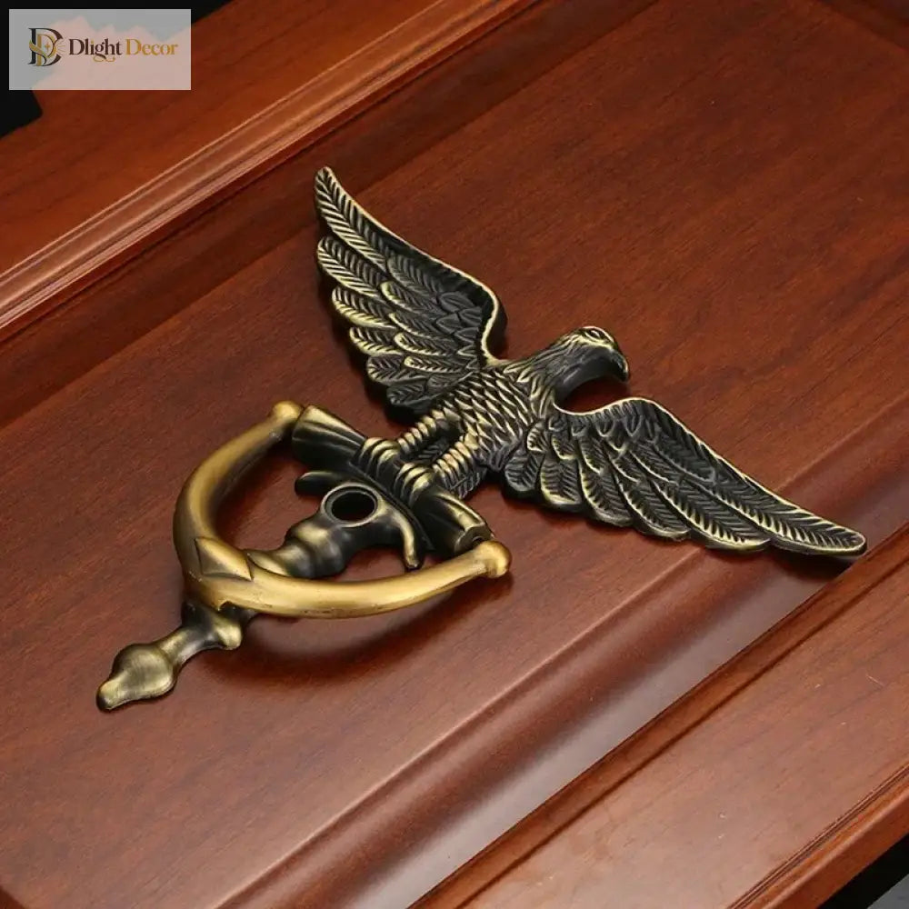 Bronze-toned eagle head door knocker mounted on wooden door, curved arched latch
