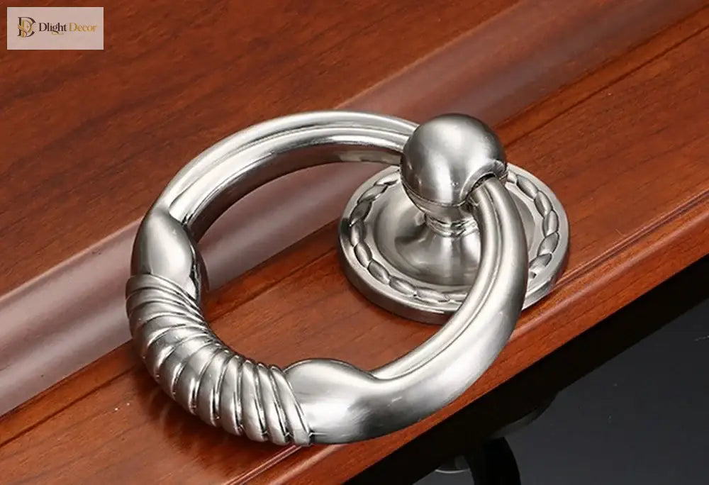 Polished chrome round door knocker with coiled handhold and circular base