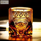 Amber-gold crystal old fashioned tumbler featuring a centered eye engraving and starcut pattern