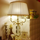 Fabric LED table lamp with pleated cream fabric shade and ornate gold candelabra base