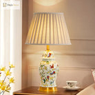 Tall ceramic table lamp, floral bird pattern on gold base, pleated fabric shade.