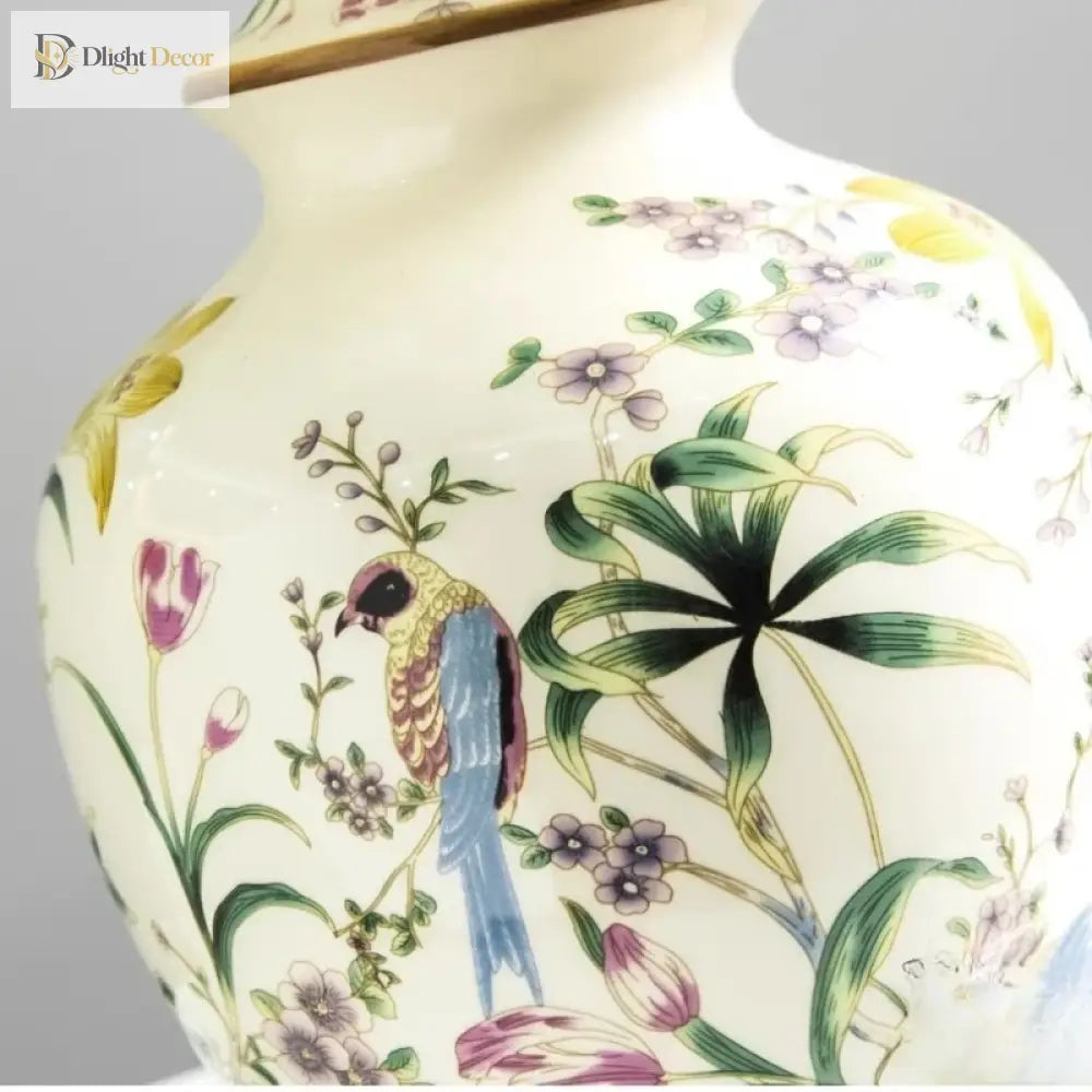 Close-up of ceramic lamp base with blue bird, purple flowers, and green leaves pattern