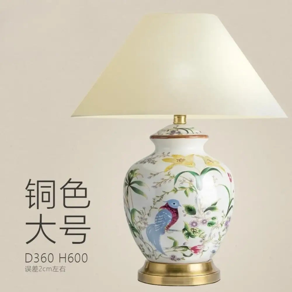 Ceramic table lamp with white shade and blue bird motif on an oval vase base