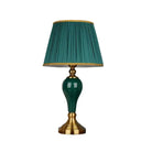 Green ceramic table lamp with pleated teal shade and gold base