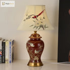 Ceramic LED desk lamp with cream shade featuring bird-and-bamboo design on a red gold base