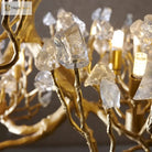 Close-up of crystal chandelier: gold-toned branches with faceted clear crystal pieces