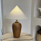Wooden desk lamp with white cone shade and brass neck on round marble base