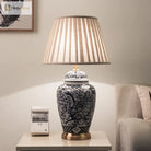 Indigo blue ceramic lamp with beige pleated drum shade and gold trim on base