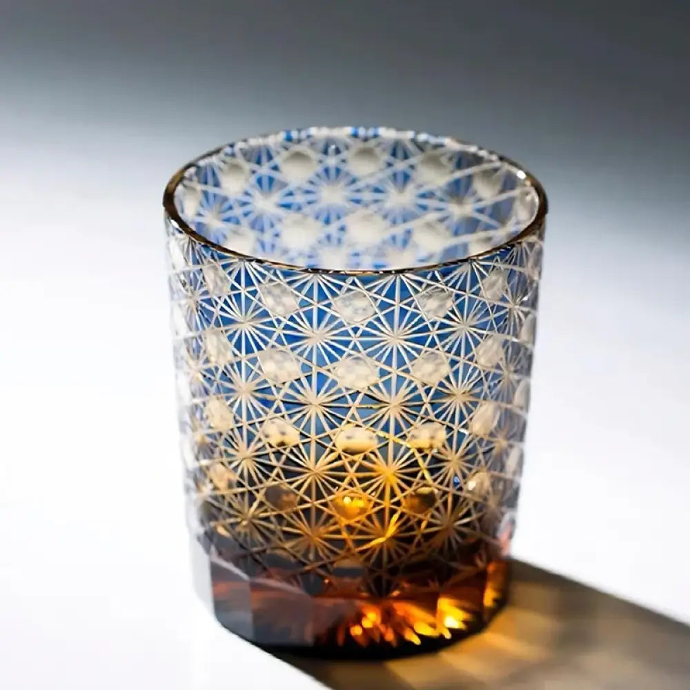 Blue cut crystal whisky glass with white starburst pattern and amber tint